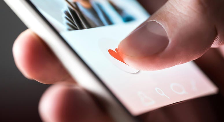 Man giving a like to photo on social media or swiping on online dating app. GrindrOnlineDatingApp