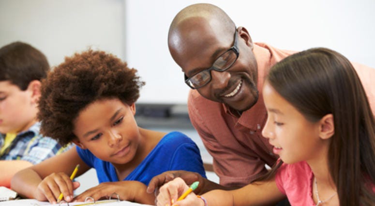 Teacher helping students with school work.