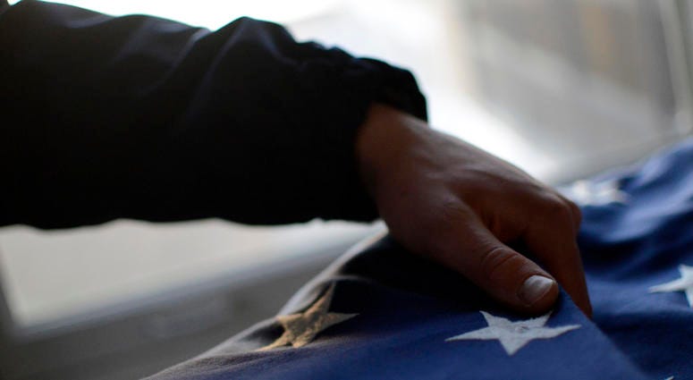 Members of Coast Guard Station Indian River fold the American flag during evening colors, Jan. 25, 2018