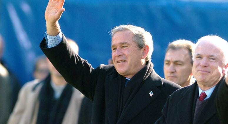 Dec. 4, 2004: President George W. Bush, accompanied by Senator John McCain (R-AZ), waves to spectators from the Navy goal line during opening ceremonies for the 105th Army vs. Navy game.