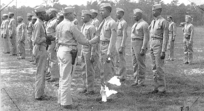 Lieutenant Colonel Frazier, Commanding Officer, Montford Point Camp, presents the World War II Victory Medal to members of the Montford Point Camp, and the 51st, and 52nd Defense Battalions." Montford Point Marines