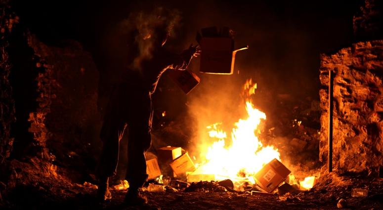 U.S. Marine Lance Cpl. Richard Carmichael with the Warfighter Exchange Service Team (WES Team), Combat Logistics Regiment 2, disposes of trash at the burn pit in Forward Operating Base (FOB) Zeebrudge, Helmand province, Afghanistan, March 6, 2013.