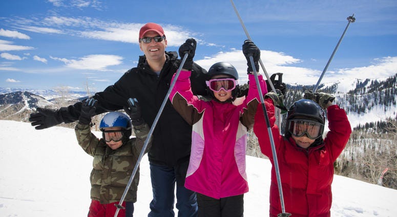 A happy father and his kids on a ski resort vacation in Park City, Utah skiing