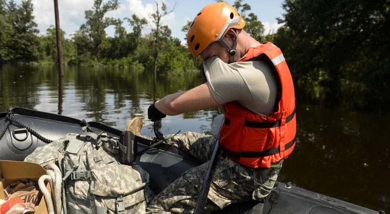 Specialist wipes his eyes as the heat and humidity during a boat patrol in Orange, Texas