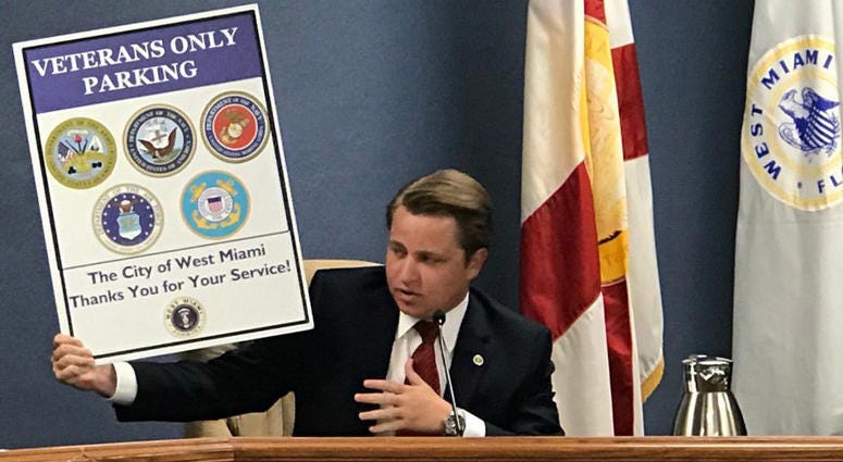 Diaz-Padron hols up veterans parking sign