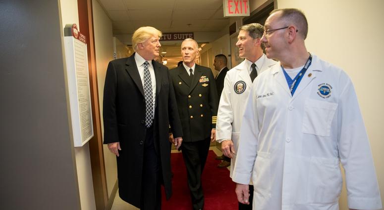 President Donald J. Trump talks with, from left to right, with Capt. Mark Kobelja, Dr. Ronny Jackson, and Dr. James Jones.