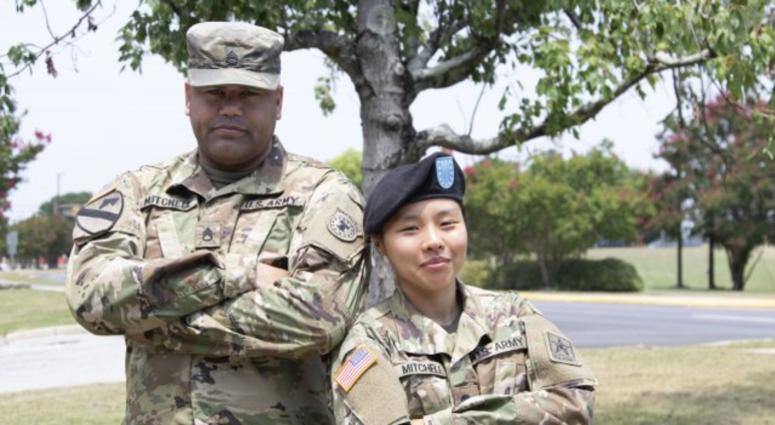 Staff Sgt. Joshua Mitchell, left, and his wife Spc. Eunjee Mitchell, right, pose during Family Day at Fort Jackson, July 31. Spc. Mitchell is a Korean immigrant who decided to enlist in the Army.