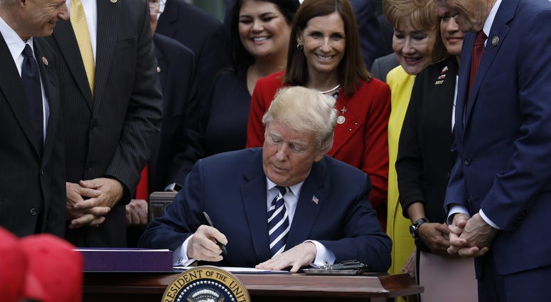 U.S. President Donald Trump signs the S. 2372-VA Mission Act of 2018 in the Rose Garden of the White House on June 6, 2018 in Washington, DC.
