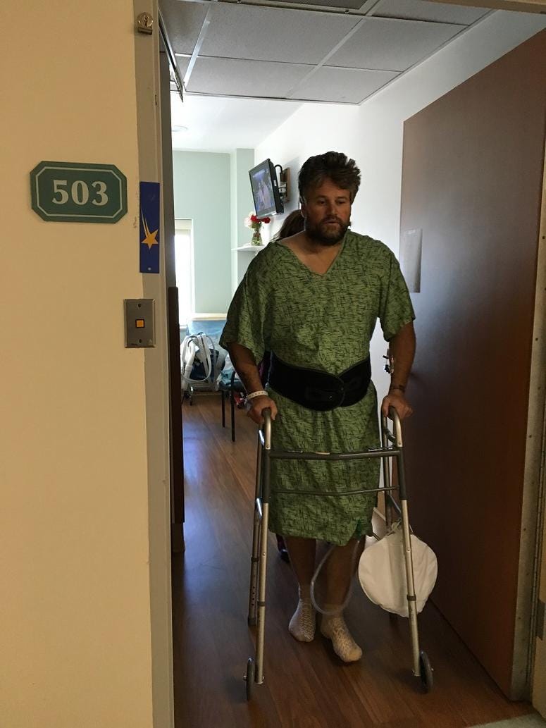 Brian Tally walking with assistance from a walker.