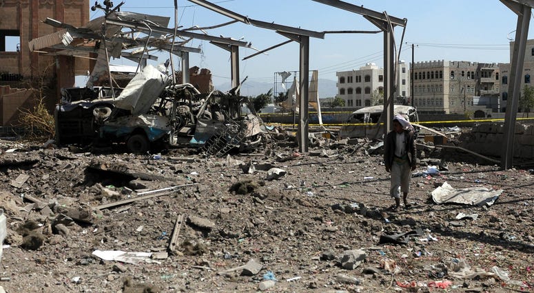A man walks near a forensic laboratory after it was hit by airstrikes in Sanaa, Yemen, on Feb. 4, 2018. T Yemen
