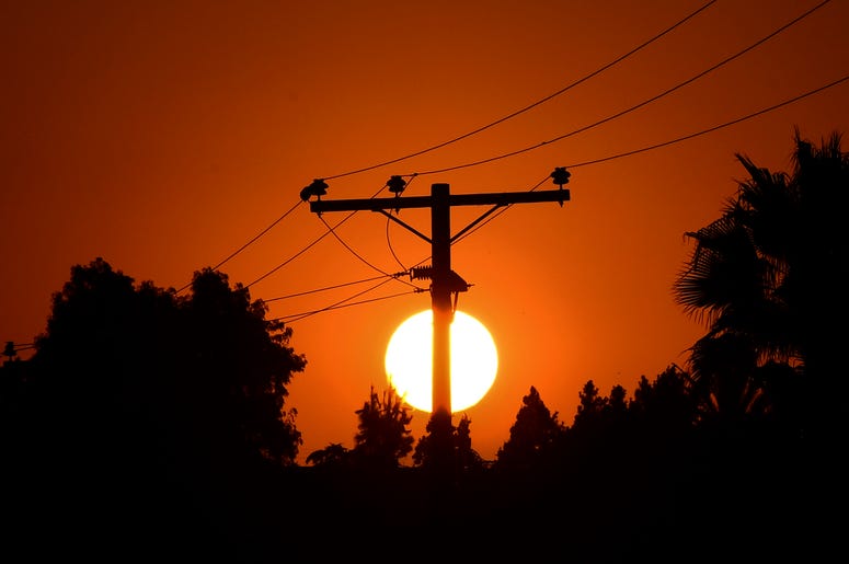 The sun sets behind power lines in Los Angeles, California on September 3, 2020, ahead of a heatwave to arrive September 4 through the Labor Day weekend prompting a statewide flex alert.