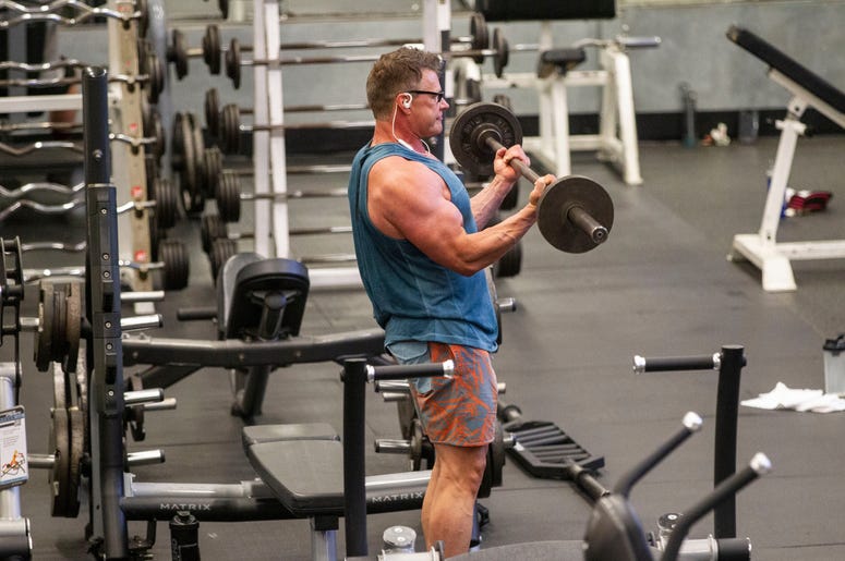 A man lifts a barbell as he works out while being socially distant from others at Momentum Fitness. Gyms Reopening A man lifts a barbell as he works out while being socially distant from others at Momentum Fitness. Gyms Reopening
