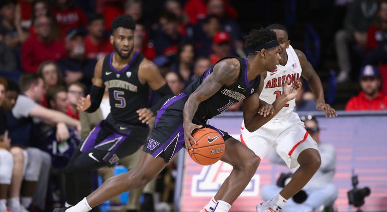 photo of an Arizona player guarding a Washington player.
