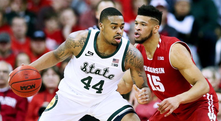 Photo of Wisconsin player guarding a Michigan State player.