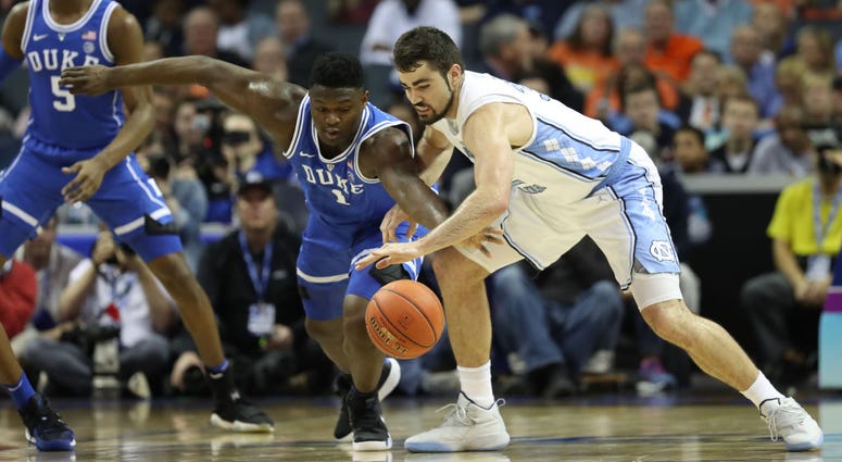 Photo of a North Carolina and Duke player fighting for the loose ball.