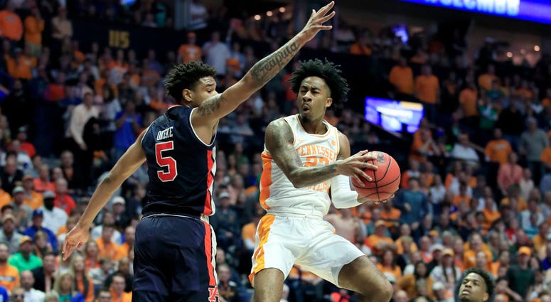 Photo of a Tennessee player being guarded by an Auburn player.