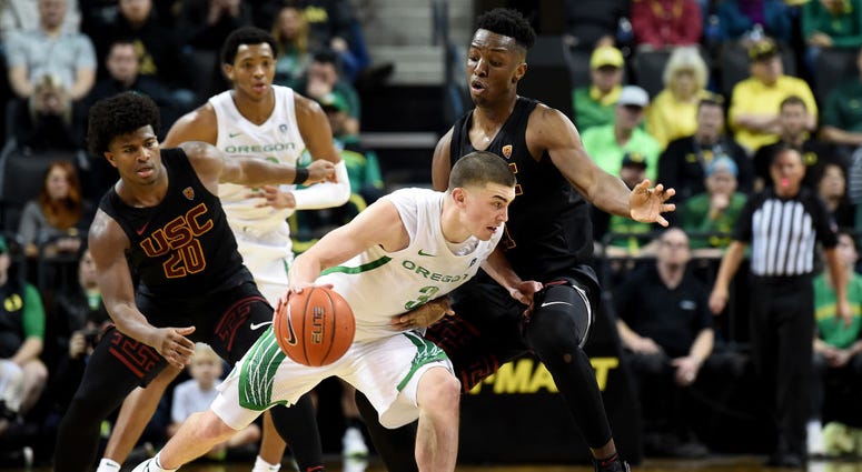 Photo of an Oregon player being guarded by an USC player.