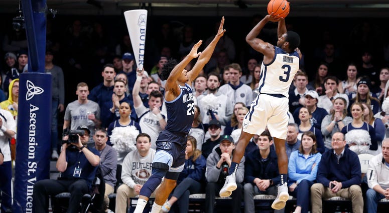 Photo of a Butler player taking a jumpshot over a Villanova player.