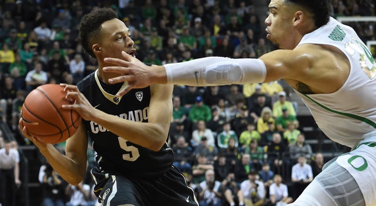 Photo of a Colorado player being guarded by an Oregon player.