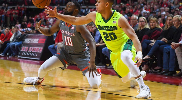 Photo of a Baylor and Texas Tech player fighting for the ball.