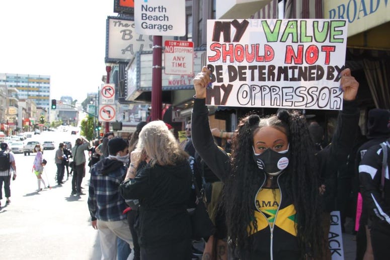 Organizer Aliyah holds her sign as part of the march Sunday. Organizer Aliyah holds her sign as part of the march Sunday.