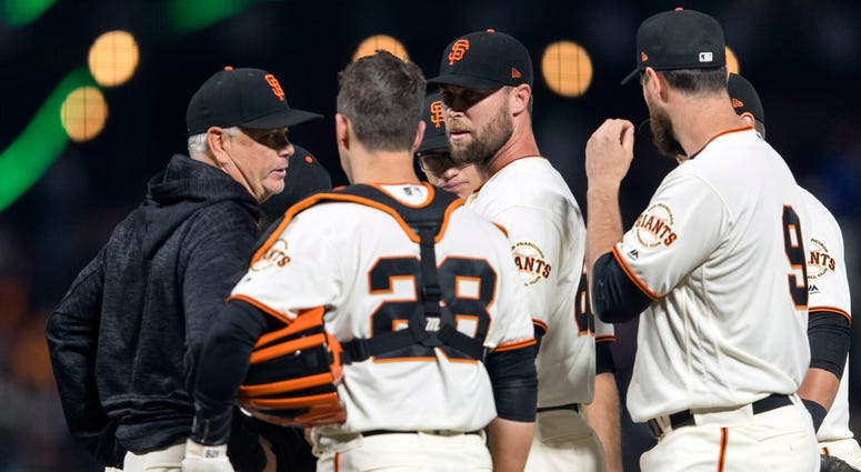 San Francisco Giants Jun 18, 2018; San Francisco, CA, USA; San Francisco Giants pitching coach Curt Young (left) talks to relief pitcher Hunter Strickland (60) and catcher Buster Posey (28) before the pitch against the Miami Marlins in the ninth inning at AT&T Park.