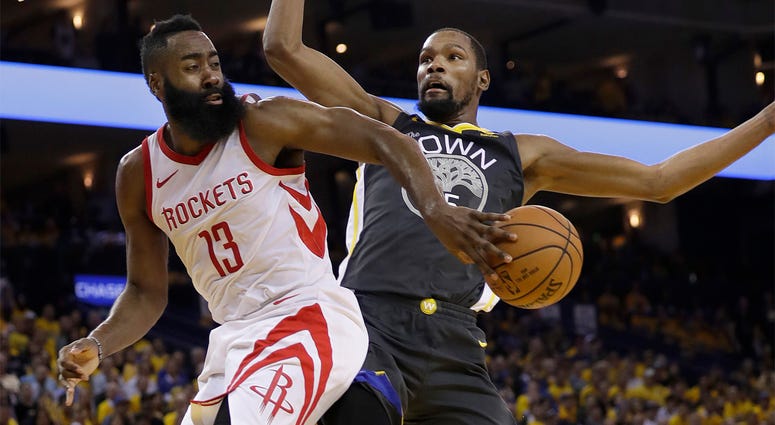AP18143087148930 Houston Rockets guard James Harden (13) passes behind Golden State Warriors forward Kevin Durant during the first half of Game 4 of the NBA basketball Western Conference Finals in Oakland, Calif., Tuesday, May 22, 2018. (AP Photo/Marcio Jose Sanchez)