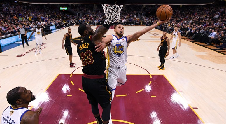 AP18160163336757 Golden State Warriors guard Stephen Curry (30 shoots around Cleveland Cavaliers forward LeBron James (23) in Game 4 of basketball's NBA Finals on Friday, June 8, 2018, in Cleveland. The Warriors defeated the Cavaliers 108-85 to sweep the series. (Gregory