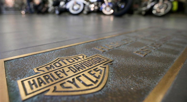 AP18176411243842 In this April 26, 2017, file photo, rows of motorcycles are behind a bronze plate with corporate information on the showroom floor at a Harley-Davidson dealership in Glenshaw, Pa. Harley-Davidson, facing rising costs from new tariffs, will begin shifting