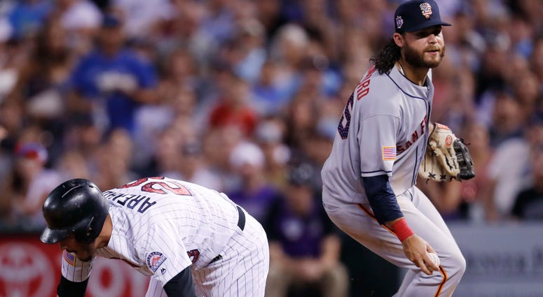 AP18184111752117 Colorado Rockies' Nolan Arenado, left, falls down after being caught in a rundown between first and second bases by San Francisco Giants shortstop Brandon Crawford in the seventh inning of a baseball game Monday, July 2, 2018, in Denver. (AP Photo/David Z