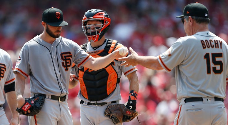 AP18231673952989 San Francisco Giants starting pitcher Andrew Suarez, left, is pulled from the game by manager Bruce Bochy, right during the third inning of a baseball game against the Cincinnati Reds, Sunday, Aug. 19, 2018, in Cincinnati. At rear is Giants catcher Nick H