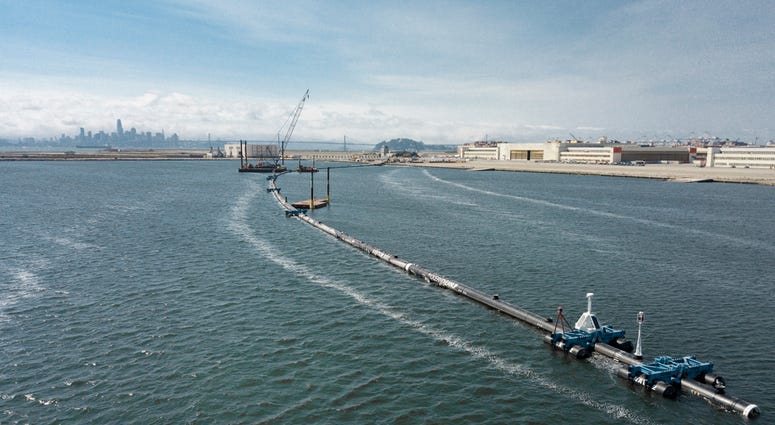 AP18250791823574 In this Monday, Aug. 27, 2018 photo provided by The Ocean Cleanup, a long floating boom that will be used to corral plastic litter in the Pacific Ocean is assembled in Alameda, Calif. Engineers will deploy a trash collection device to corral plastic litte
