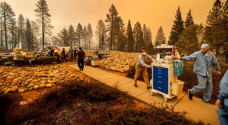 Medical workers move equipment from a makeshift emergency room while the Feather River Hospital burns as the Camp Fire rages through Paradise, Calif., on Thursday, Nov. 8, 2018 Medical workers move equipment from a makeshift emergency room while the Feather River Hospital burns as the Camp Fire rages through Paradise, Calif., on Thursday, Nov. 8, 2018