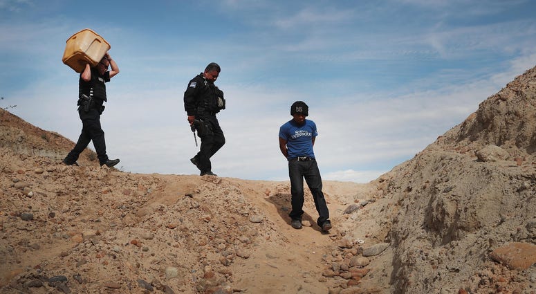 A migrant is taken into custody by Mexican police A migrant is taken into custody by Mexican police