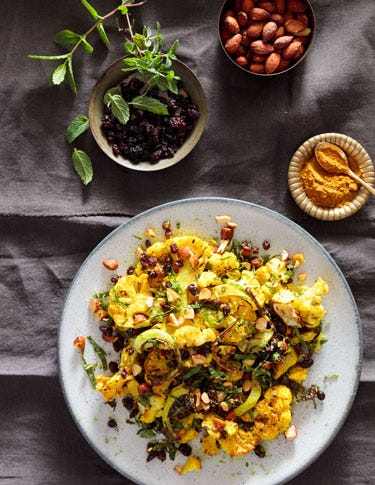 Blistered Curry Cauliflower With Mint, Currants, And Toasted Almonds Reprinted from The Vibrant Life by Amanda Haas with permission by Chronicle Books, 2019