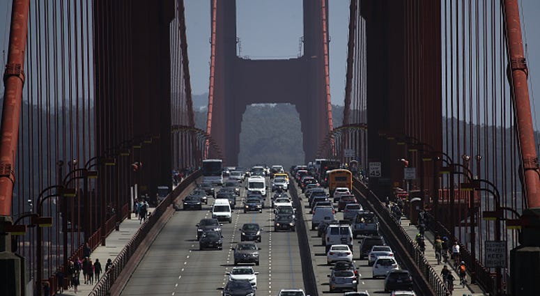 Cars drive over the Golden Gate Bridge Cars drive over the Golden Gate Bridge