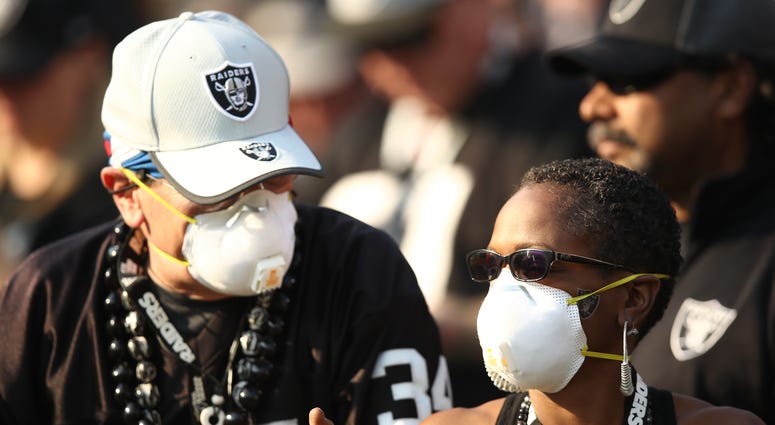 Fans wear face masks in the stands during the NFL game between the Oakland Raiders and the Los Angeles Chargers at Oakland-Alameda County Coliseum on November 11, 2018 in Oakland, California. Fans wear face masks in the stands during the NFL game between the Oakland Raiders and the Los Angeles Chargers at Oakland-Alameda County Coliseum on November 11, 2018 in Oakland, California.