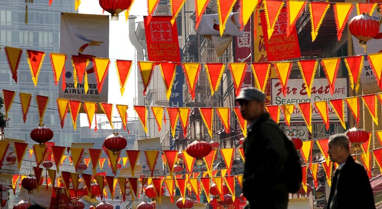 edestrians walk by red and yellow banners that are strung across Grant Street for Chinese New Year in San Francisco's Chinatown district on February 3, 2011 edestrians walk by red and yellow banners that are strung across Grant Street for Chinese New Year in San Francisco's Chinatown district on February 3, 2011