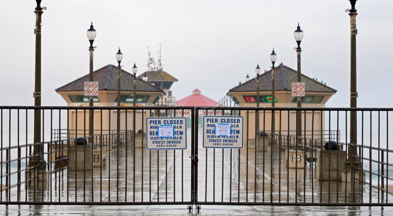A sign explaining the closure of the Huntington Beach Pier is seen on March 24, 2020 in Huntington Beach. A sign explaining the closure of the Huntington Beach Pier is seen on March 24, 2020 in Huntington Beach.
