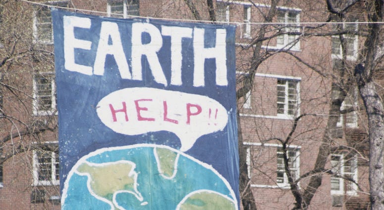 A crowd of people gather near a large poster that shows a speach bubble from planet Earth that reads 'Help!!', on the occaision of the first Earth Day conservation awareness celebration, New York, New York, April 22, 1970. A crowd of people gather near a large poster that shows a speach bubble from planet Earth that reads 'Help!!', on the occaision of the first Earth Day conservation awareness celebration, New York, New York, April 22, 1970.