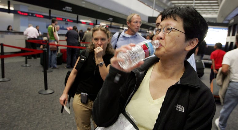 A United Airlines passenger takes a sip of water before throwing away the bottle at a security checkpoint at San Francisco International Airport August 10, 2006 in San Francisco. A United Airlines passenger takes a sip of water before throwing away the bottle at a security checkpoint at San Francisco International Airport August 10, 2006 in San Francisco.