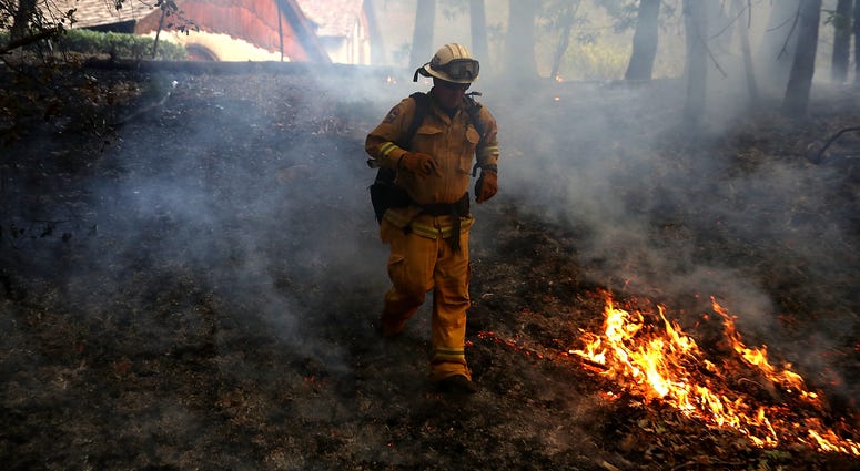 : A CalFire chief runs past burning grass during a firing operation while battling the Tubbs Fire on October 12, 2017 near Calistoga, California. : A CalFire chief runs past burning grass during a firing operation while battling the Tubbs Fire on October 12, 2017 near Calistoga, California.