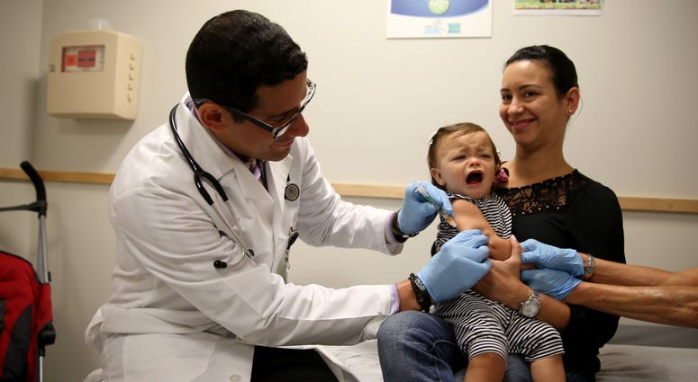 aniela Chavarriaga holds her daughter, Emma Chavarriaga, as pediatrician Jose Rosa-Olivares, M.D. administers a measles vaccination during a visit to the Miami Children's Hospital on June 02, 2014 in Miami, Florida aniela Chavarriaga holds her daughter, Emma Chavarriaga, as pediatrician Jose Rosa-Olivares, M.D. administers a measles vaccination during a visit to the Miami Children's Hospital on June 02, 2014 in Miami, Florida.
