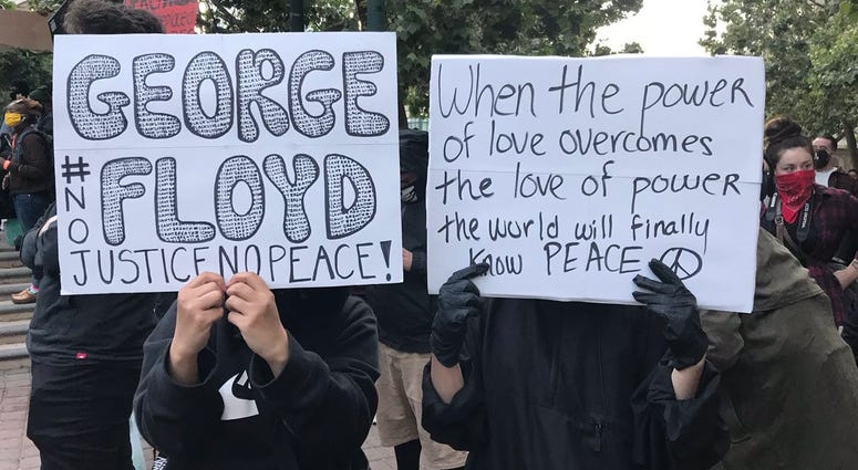 Signs held at an Oakland protest over the death of George Floyd in Minneapolis.