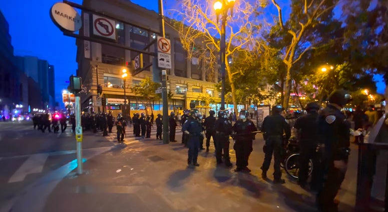 Police stand on Market St. In San Francisco as looters hit stores along the strip.
