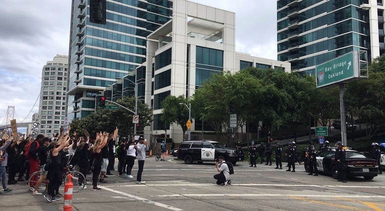 Protesters are stopped from entering a Bay Bridge on-ramp by CHP officers at a San Francisco rally.