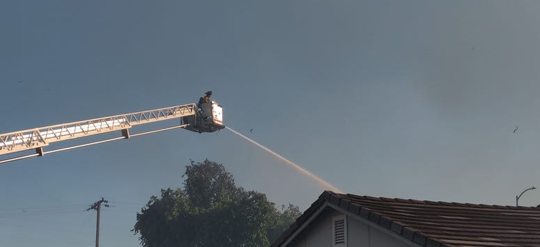 A firefighter douses a house in Suisun City during a marshland fire. A firefighter douses a house in Suisun City during a marshland fire.