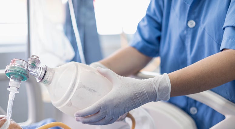ICU and hospital cases drop in Bay Area as engineers work to increase supply of critical equipment Doctor holds oxygen over ICU patient