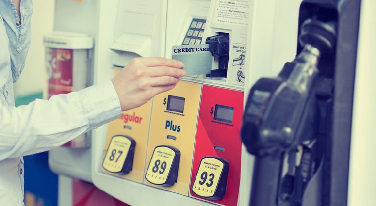 Woman hand swiping credit card at gas pump station Woman hand swiping credit card at gas pump station