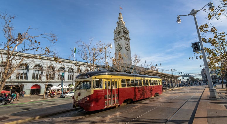 San Francisco Ferry Building and MUNI MUNI Train in front of San Francisco Ferry Building in Embarcadero in San Francisco